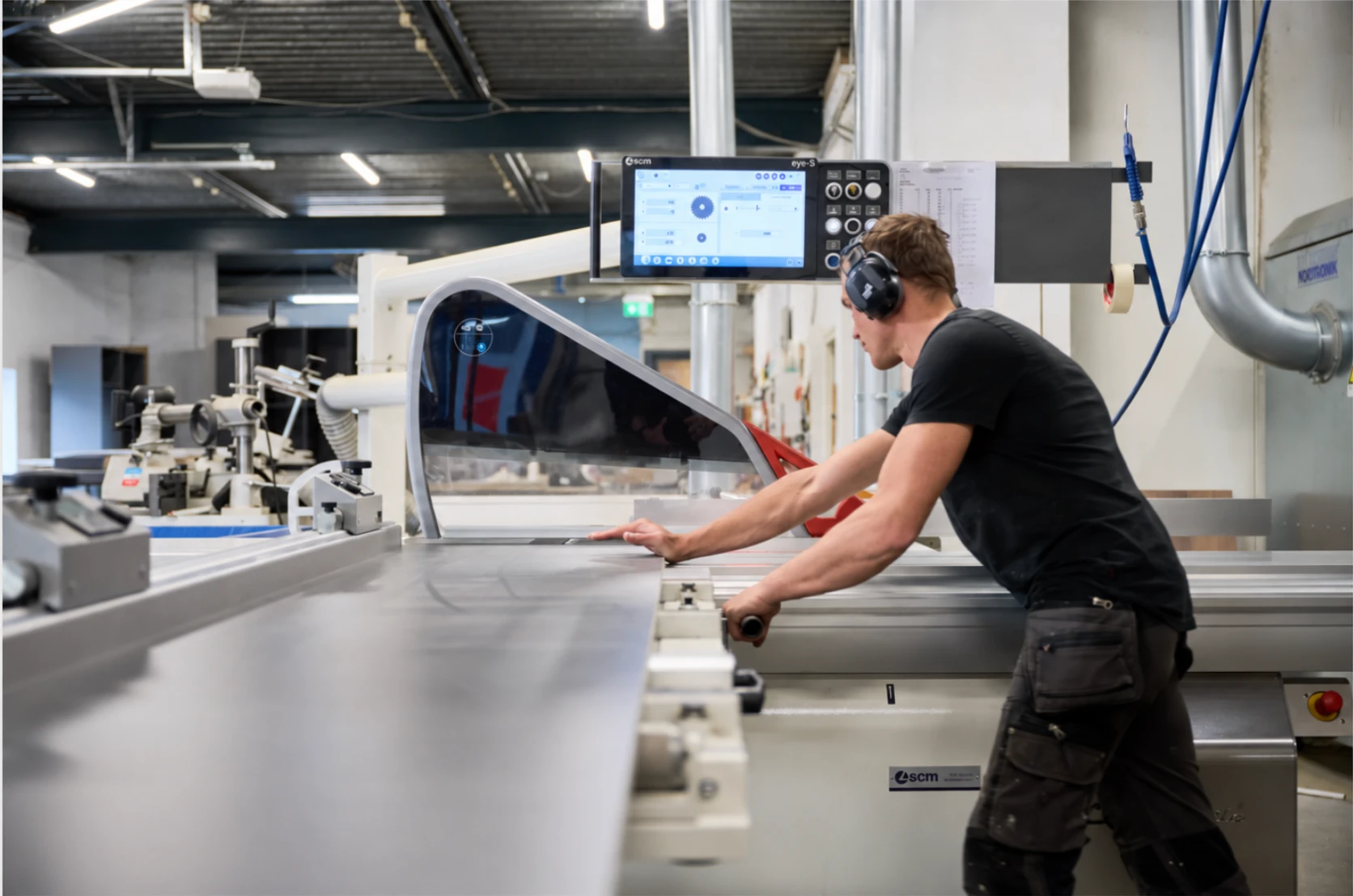 Vakman zaagt plaatmateriaal op een formaatzaag met digitale besturing